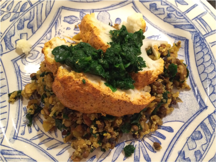 Roasted Whole Cauliflower topped with Steamed Spinach on a bed of Vegetarian Delight